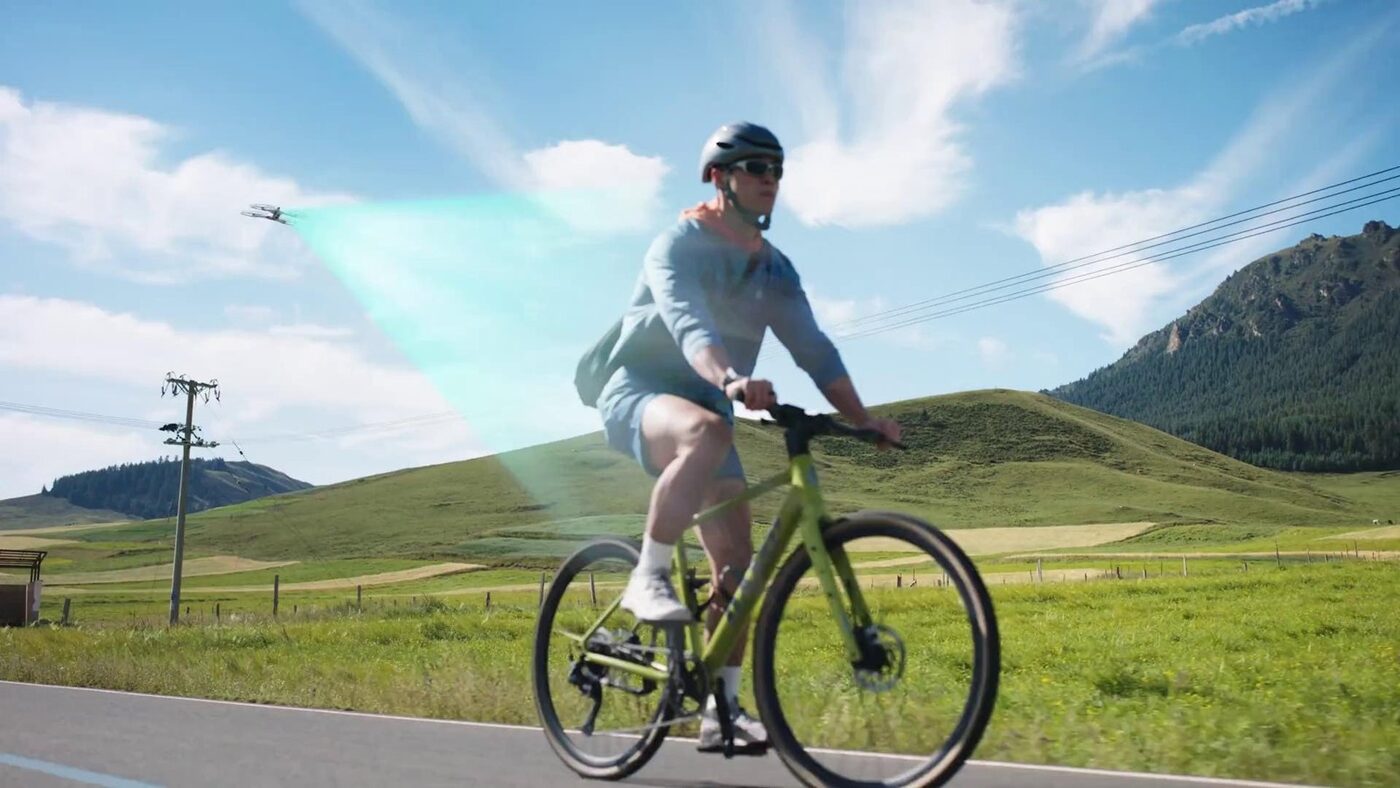 Cyclist riding a road bike with an Antigravity A1 drone following alongside